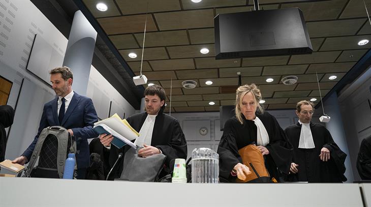 Oxfam-directeur Michiel Servaes in de rechtszaal samen met advocaten