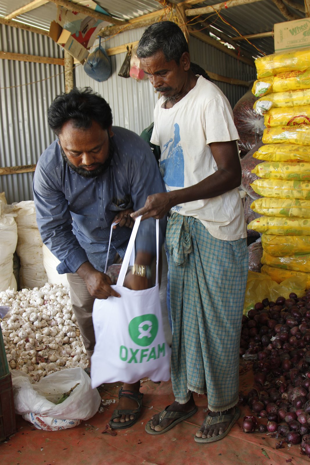180430_Bangladeshi store keeper MD Ruhulamin packs fresh veges & spices bought with Oxfam cash vouchers for Rohingya refugee Kefayatullah.JPG