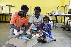 Gideon Imar en zijn gezin ontvangen hulpgoederen in het evacuatie-centrum in Vanuatu.