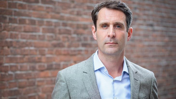 Hulpverlener van een Oxfam-partner staat naast zakken vol eten