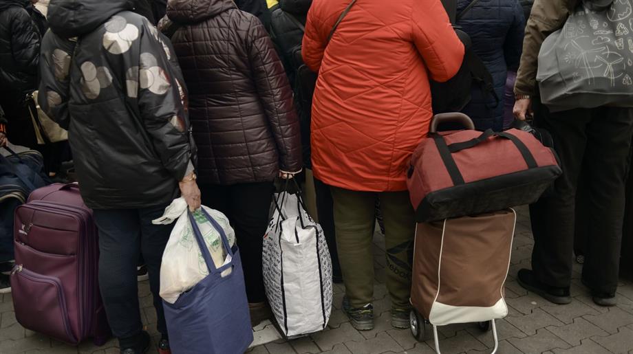 Vluchtelingen aan de grens, onderweg met hun spullen.