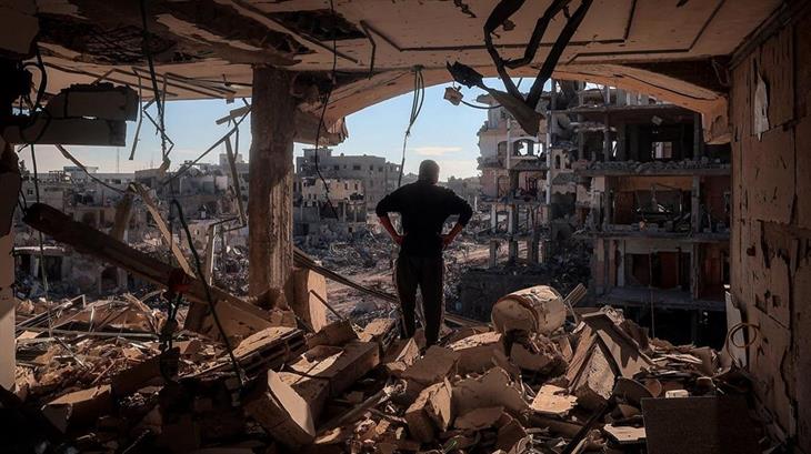 man staat temidden van ravage in Gaza