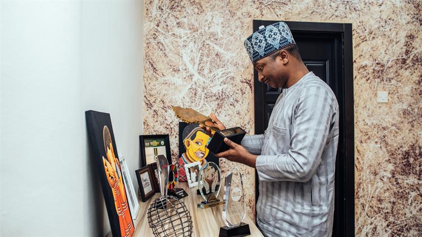 Hamzat bij zijn prijzentafel met in zijn hand de award van de Future Africa Leaders Foundation.