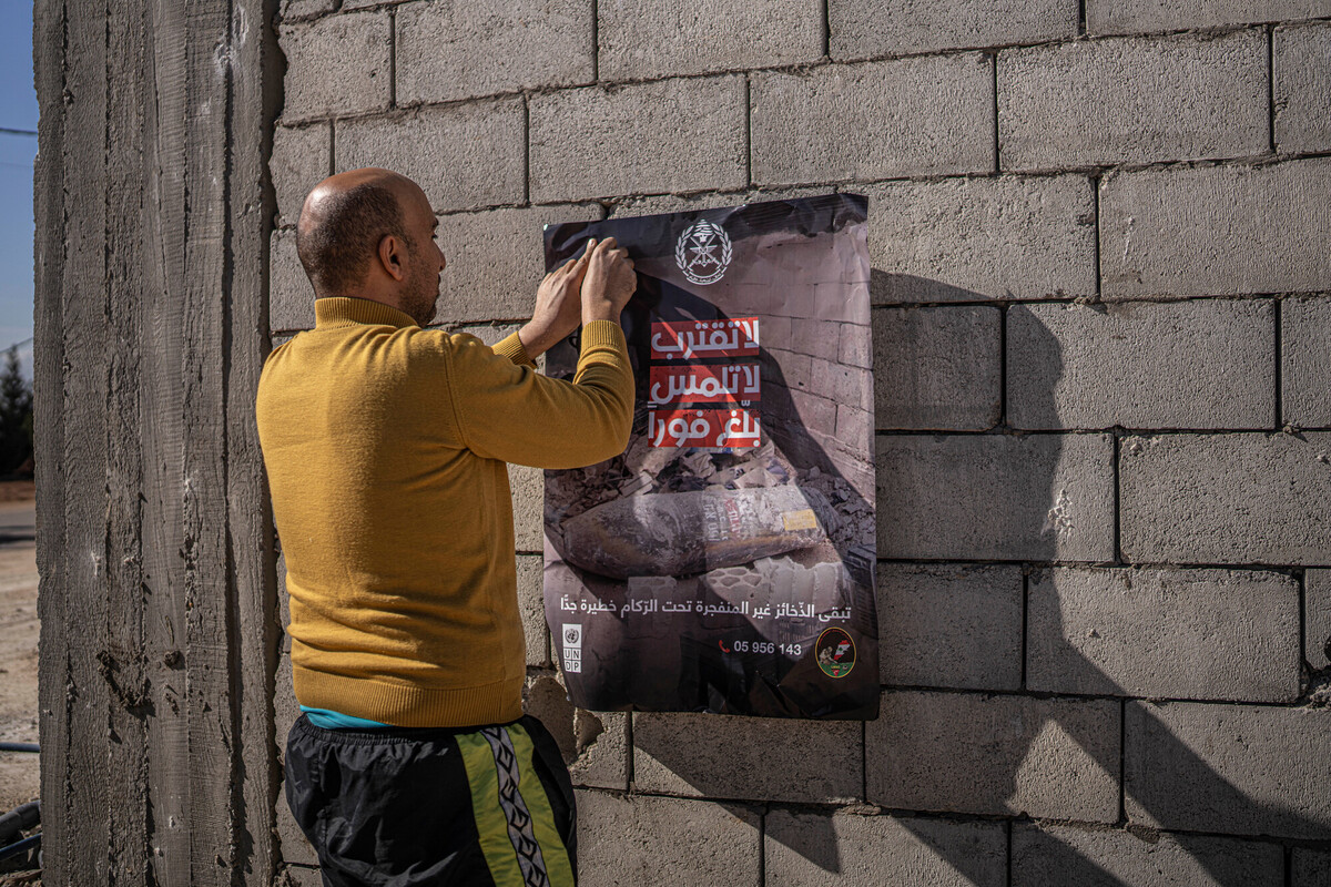 Libanon, 2025 - Saad plakt posters om zijn dorpsgenoten te waarschuwen voor niet-ontploft materiaal