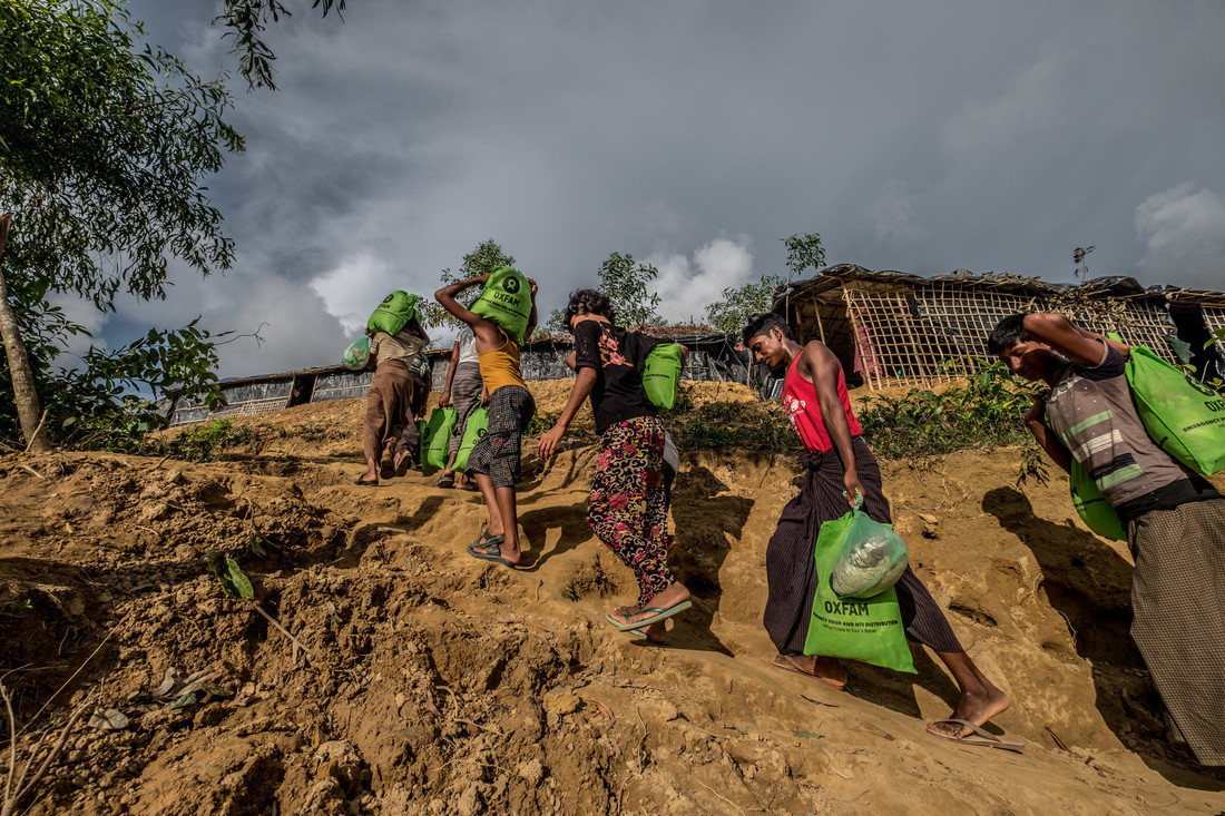 OGB_109654_Refugees carry Oxfam food parcels through Thengkhali Camp.jpg