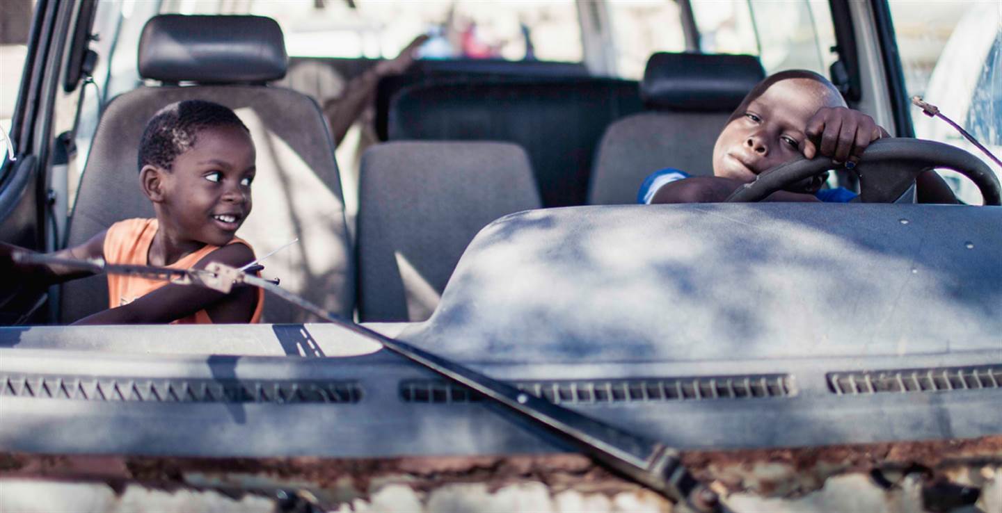 Wat hebben we bereikt? Foto van twee jongens in een auto, gemaakt in Mozambique