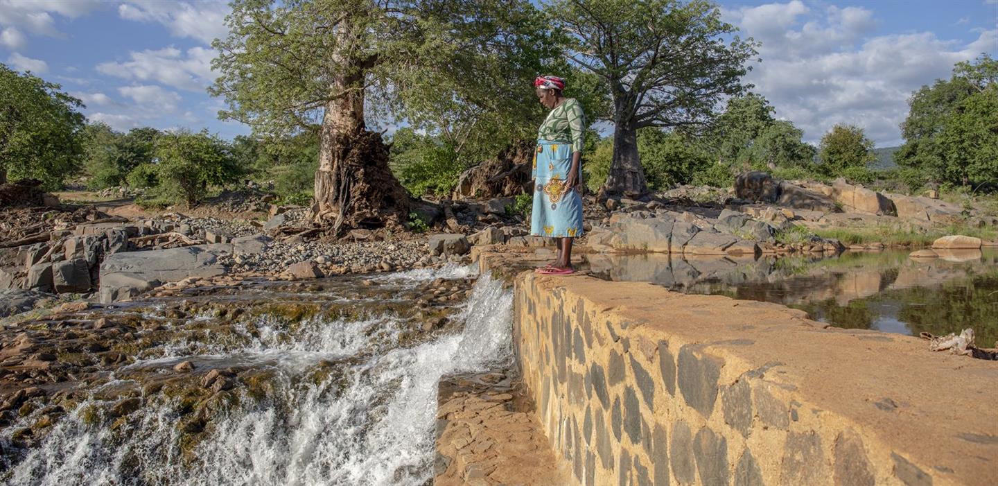 Boerin Sarah staat bij de rivier die haar van water voorziet